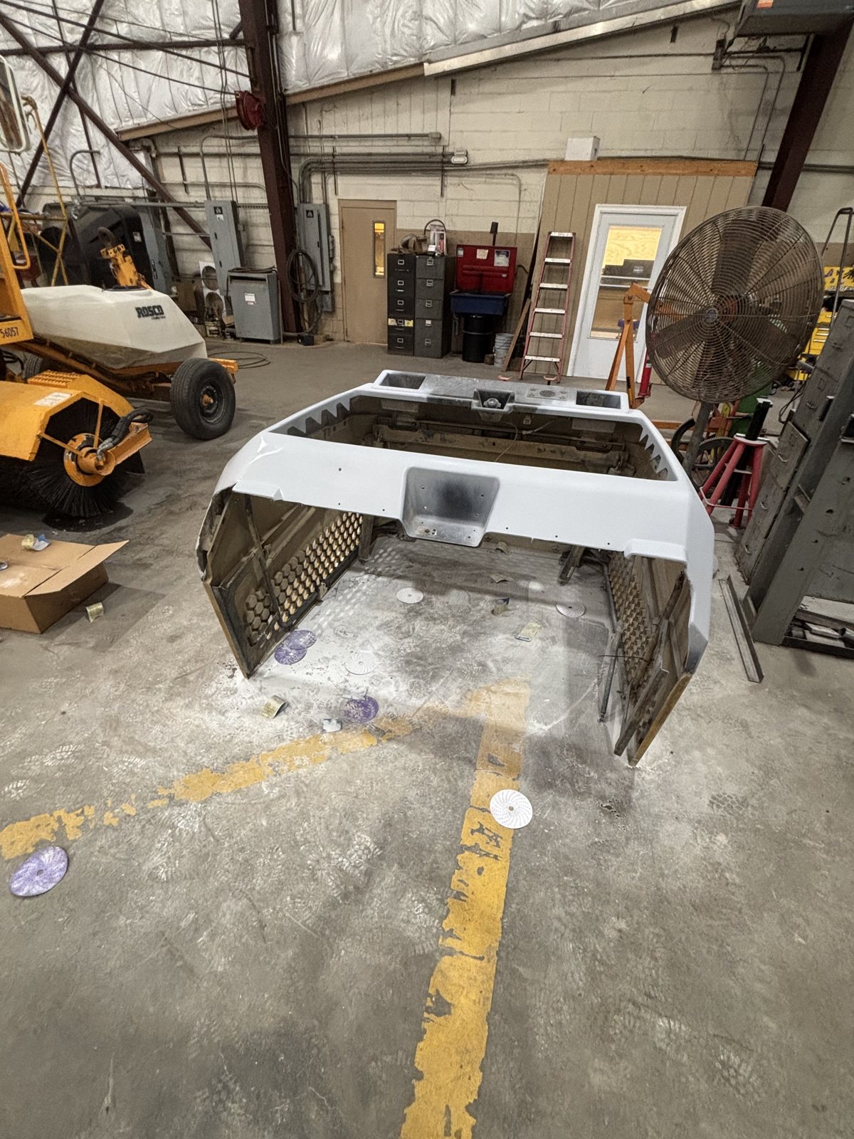 Refinished fiberglass hood panel for a CAT loader