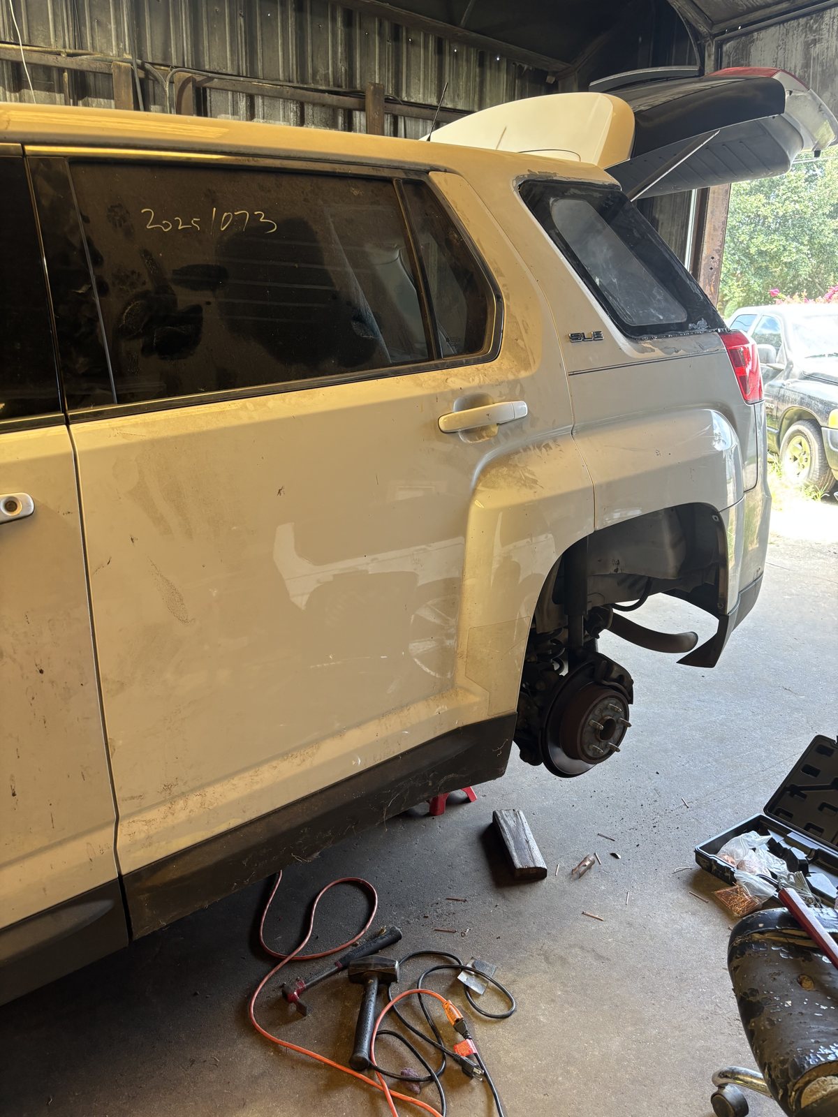 Pickup cab with the door removed and tools laid out.